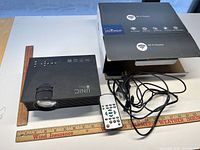Projector, remote, cables, box, ruler for scale