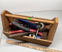 overview of wooden toolbox with assorted tools inside