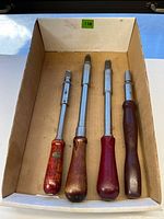 Four drill-drivers in box showing varying handle finishes and overall size