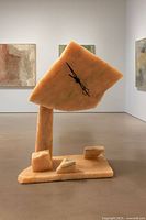 Full frontal view of stone clock showing dial, support and base