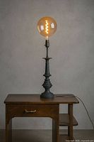Full view of lamp on table, bulb illuminated