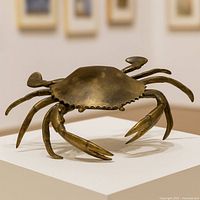 Top view of brass crab sculpture on pedestal showing full form and patina