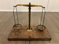 Full view of balance showing beam, pans and wood base