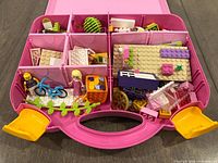 Open case showing compartments filled with bricks, figures and bicycle