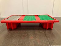Side view of red LEGO lap table showing plates installed