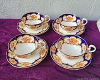 front angled view of four cup and saucer sets