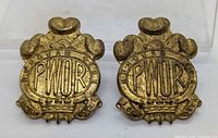 Front view of both PWOR cap badges
