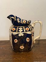 Front view of cobalt blue Imari-style ceramic jug with floral motifs
