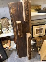 Front view of the live edge wood shelf showing full plank and three protruding block shelves