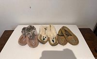 All three pairs of moccasins side by side on table