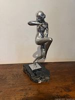 Front view of silver-tone nude dancer on marble base