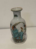 Front view of porcelain vase showing bird, rock and floral decoration