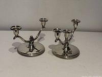 Two candelabra showing two-light and three-light holders