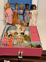 Open pink Barbie case showing all dolls and compartments
