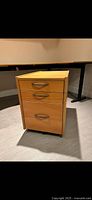Mobile 3-drawer cabinet with closed drawers, light wood finish