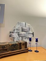 Collage frame wrapped, wooden trinket chest closed, two blue glass candlesticks