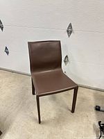 Front view of one brown leather dining chair