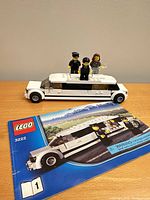 Built white limousine model with three minifigures on roof and instruction booklet