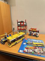 Assembled LEGO City Corner set with bus, bus stop, building, bike shop kiosk and instructions