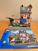 Front view of assembled LEGO City House set 8403 beside instruction booklet