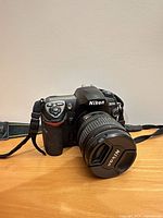 Front three-quarter view of Nikon D200 with attached lens and strap