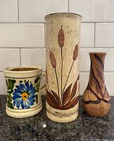 Front view of three pottery items showing designs and relative sizes