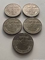 Five Jacques Cartier Canadian dollar coins displayed