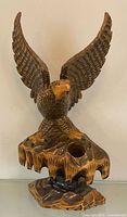 Full view of carved wooden eagle statue on base