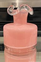 Front view of pink glass vase showing frilled clear rim and body color