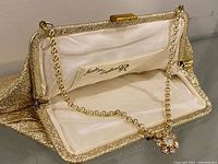 Open purse showing chain handle, satin lining and Made in England stamp