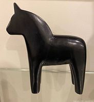 Full side view of black wooden Dala horse figurine