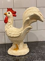 Full view of ceramic rooster figurine showing overall form and base