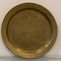 Front view of brass plate showing engraved design and border