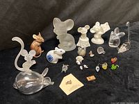 Group view of all glass, frosted glass and porcelain animal figurines on black background