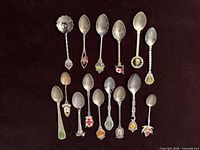 Full set of 14 Canadian souvenir teaspoons laid out in two rows