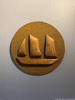 Front view showing full circular burlap panel with carved cedar schooner relief