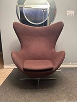 Front view of brown fabric swivel lounge chair showing high winged back and seat pad