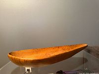 Top view of elongated wooden bowl showing interior grain and wear
