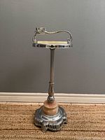 Full view of chrome standing ashtray showing handle, stem, onyx collar and ornate base