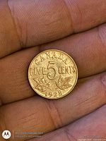 Reverse of 1928 Canada 5-cent coin showing date and maple leaves
