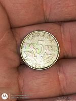 Reverse of 1922 Canada 5-cent coin showing maple leaves and rainbow toning