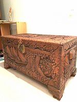 Front view of carved chest showing overall design and feet
