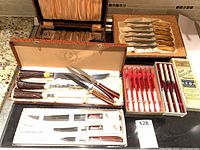 Overview of multiple boxed knife sets laid out on counter