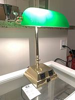 Front view of brass banker’s lamp, illuminated