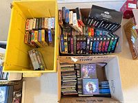 Three containers holding CDs and VHS tapes