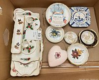Overview of china lot in box showing trays, souvenir plates, trinket dishes