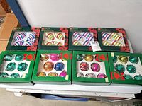 All eight boxed sets of Holiday Collection ornaments displayed on table
