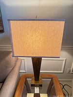 Full view of lamp lit showing wood body and shade