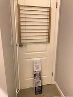 Drying rack folded on door, boxed second rack leaning against door