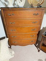 Front view of wooden 5-drawer dresser showing all drawers and hardware